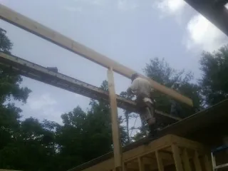 Carpenter setting a ridge beam over a new addition frame — Ice Dam Removal by Roofing Brothers in Caryville
