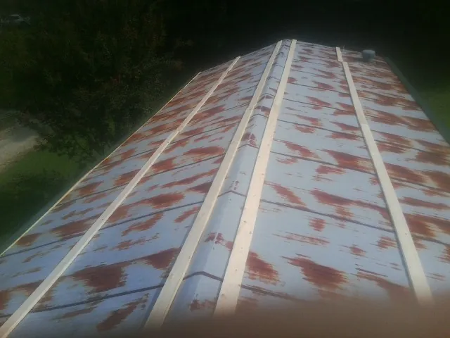 Rusted metal roof panels with new wood purlins before replacement — Storm Damage Roof Repair in Caryville by Roofing Brothers