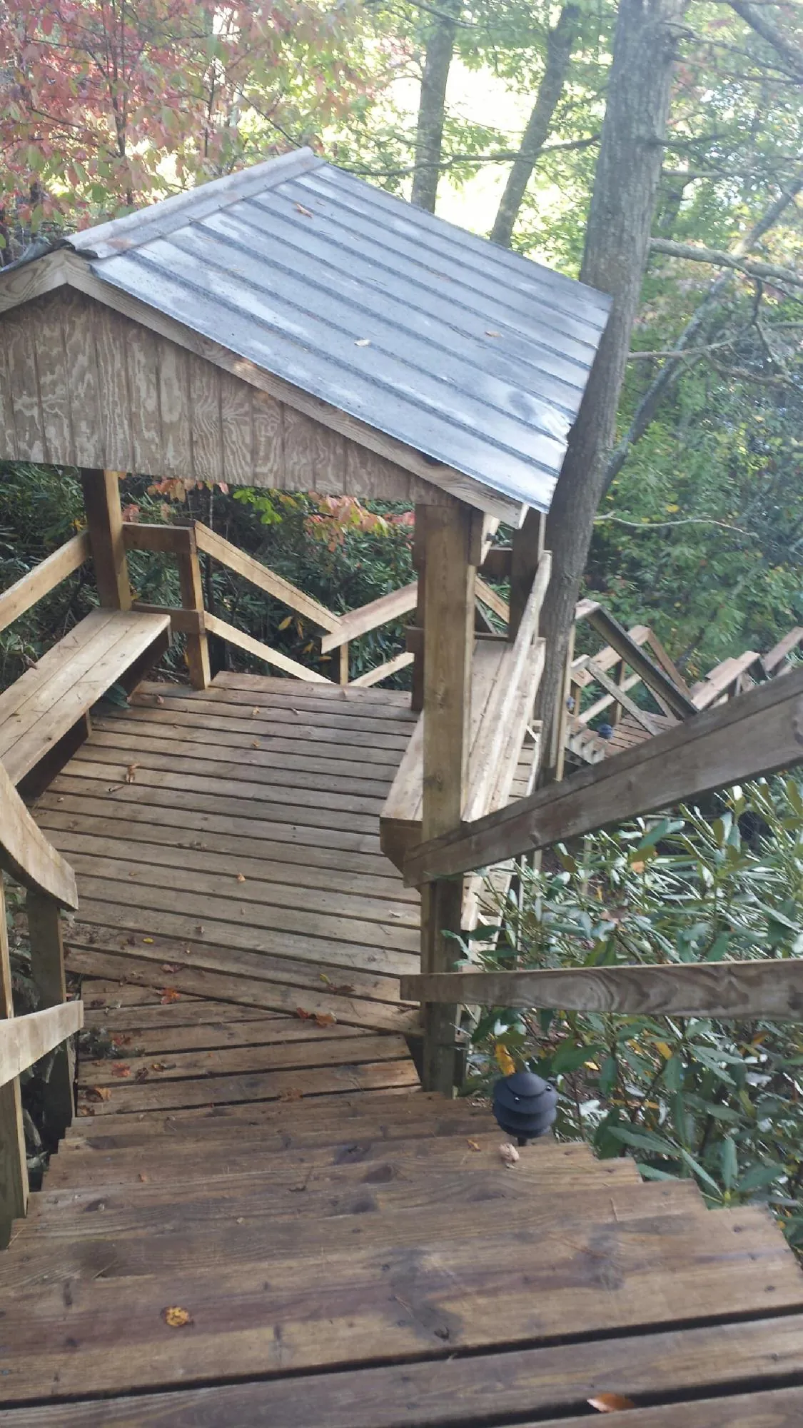 Metal roofed shelter over wooden steps on a wooded walkway — Skylight Repair & Installation work by our crew in Caryville