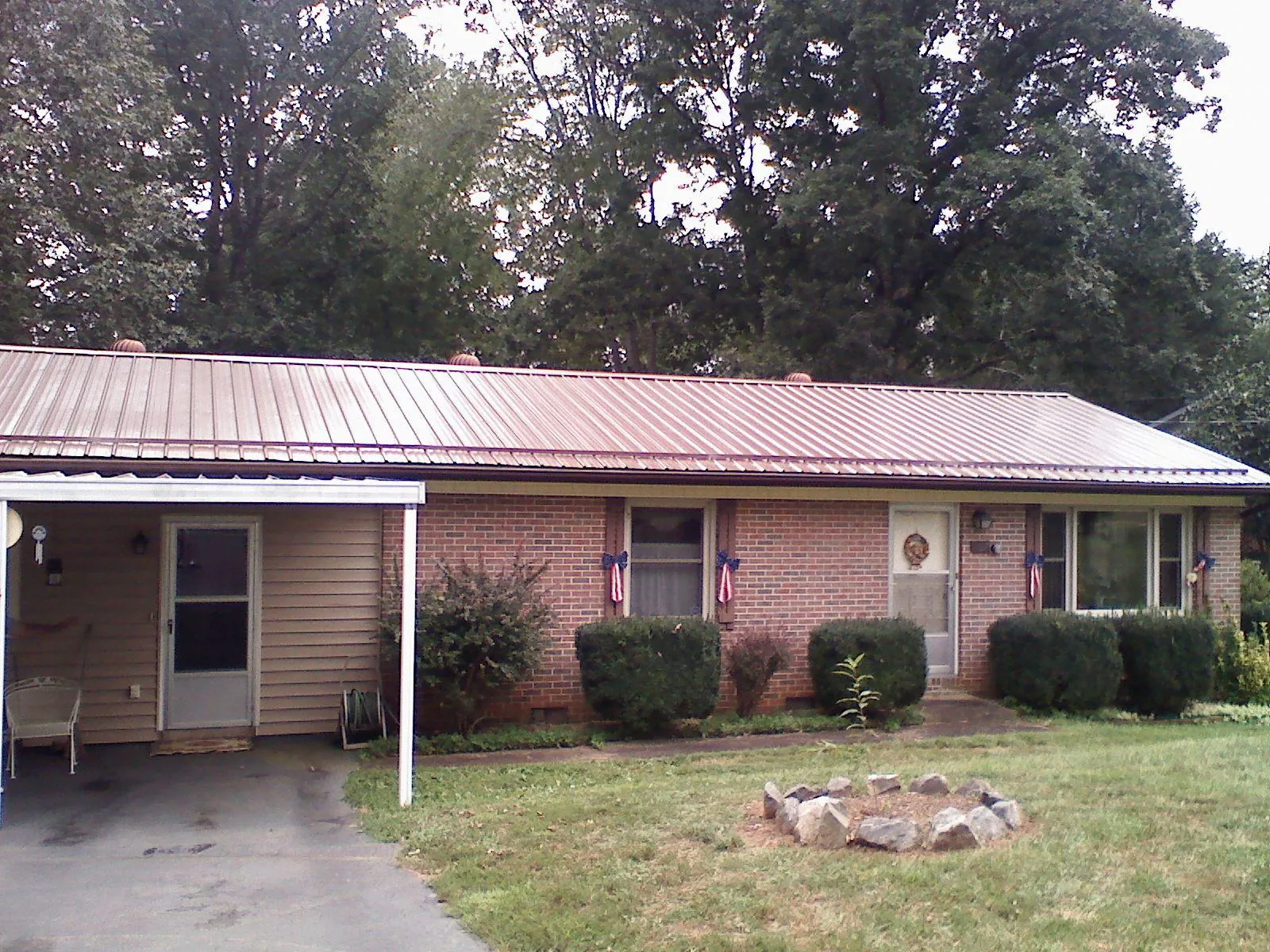 Bronze metal roof and carport on a brick ranch home — Roof Repair work by our crew in Caryville